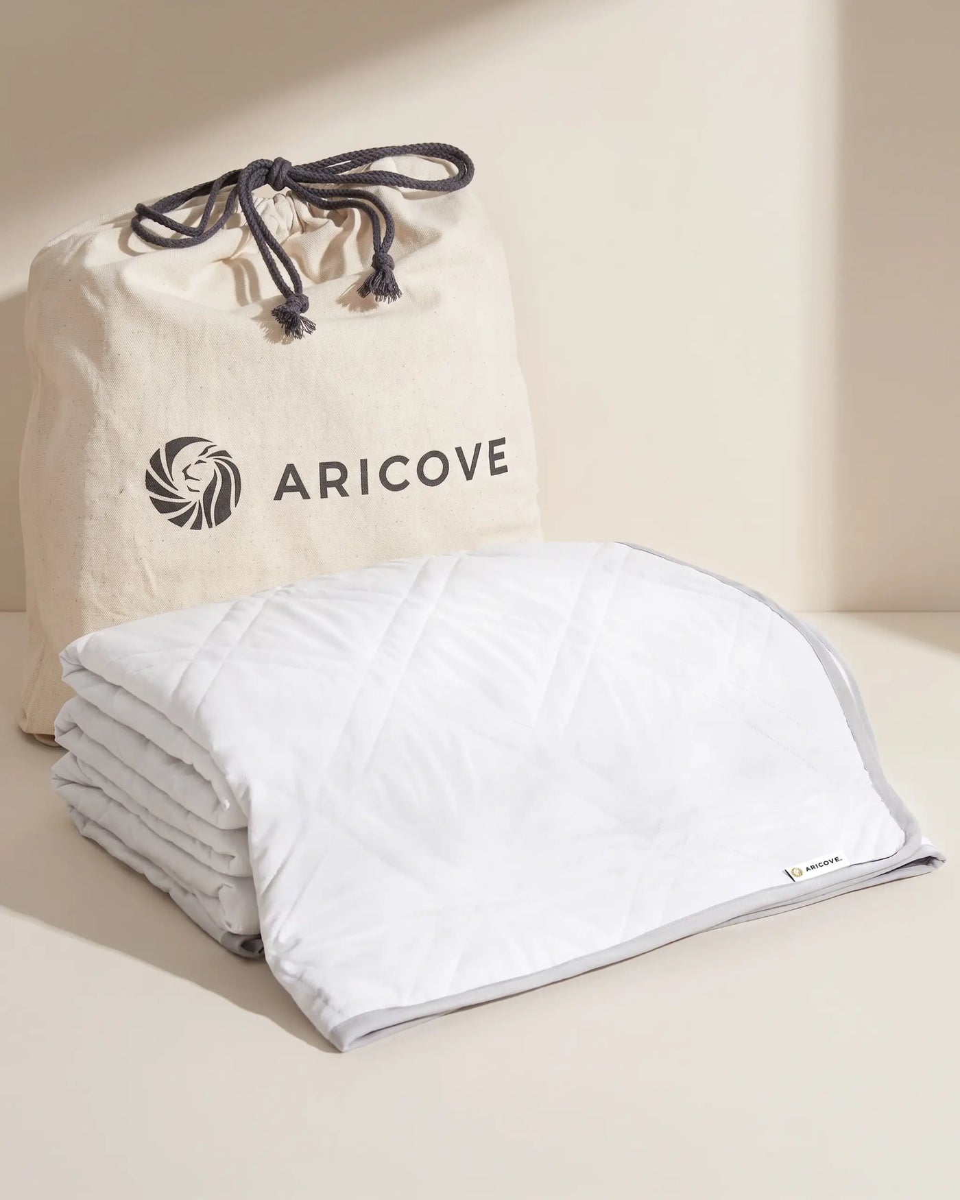 Aricove weighted blanket in king size, rolled beside the Aricove travel bag