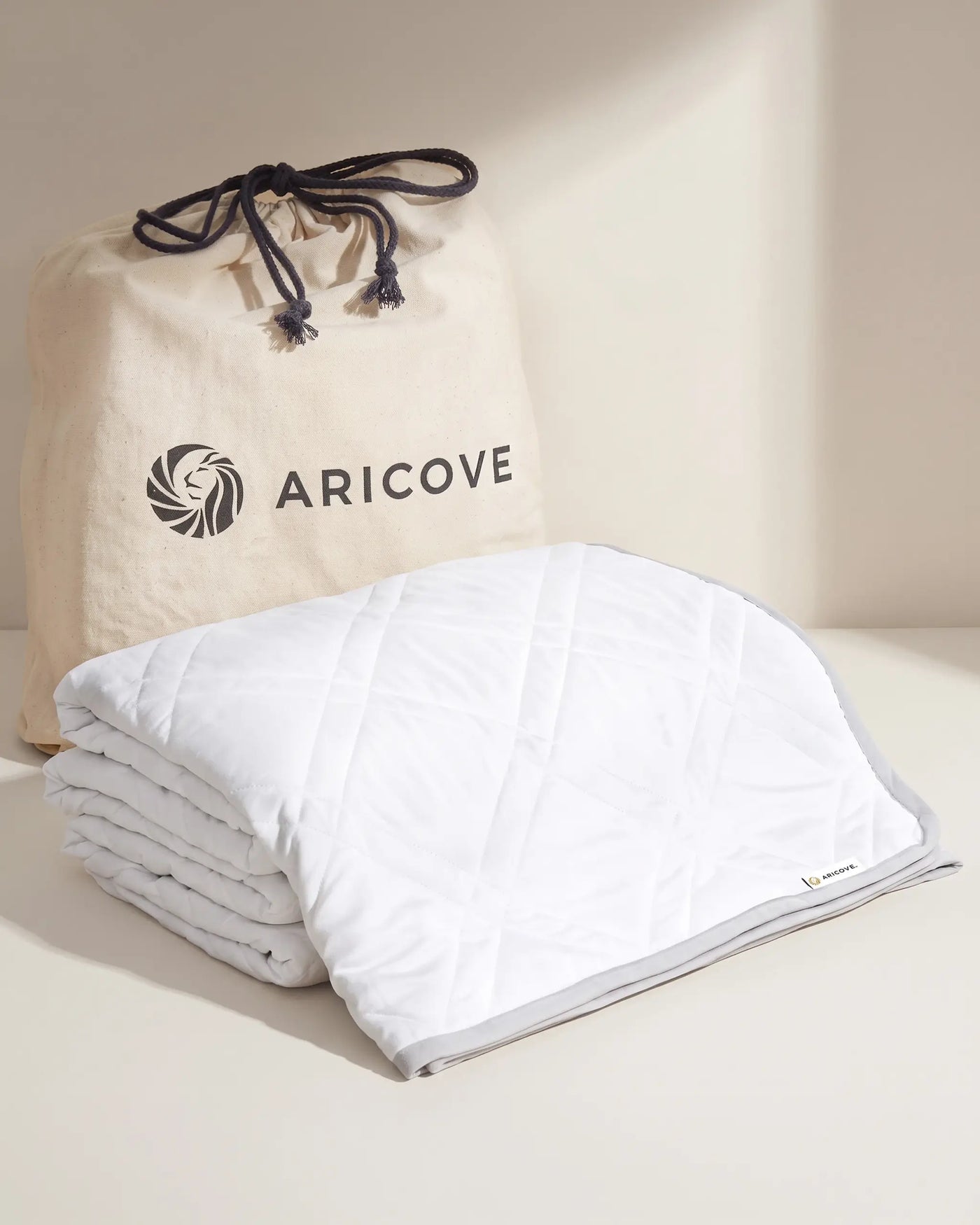 Aricove weighted blanket in queen size, rolled beside the Aricove travel bag